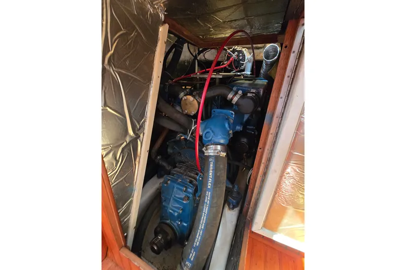 Slide: The Image of Engine compartment of a 1989 Fairweather Mariner 39 boat, featuring blue machinery and wiring. - 28