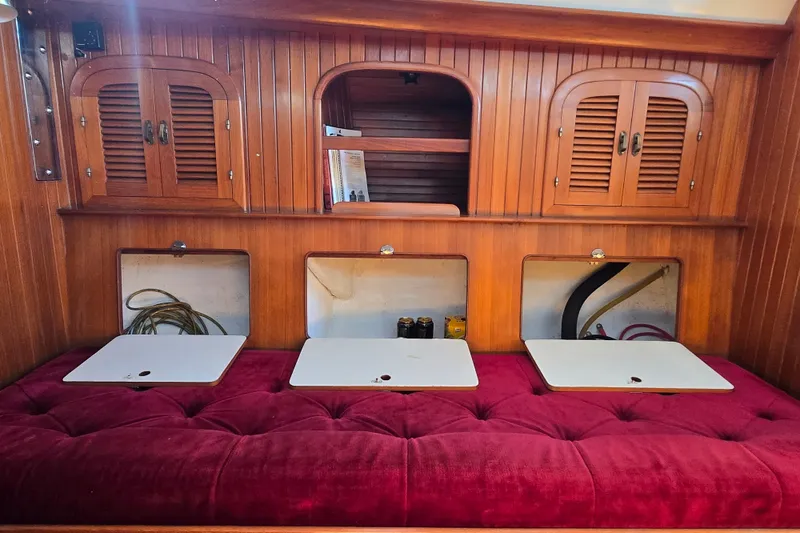 Slide: The Image of Interior of 1989 Fairweather Mariner 39 with wooden cabinets and red cushioned seating. - 24
