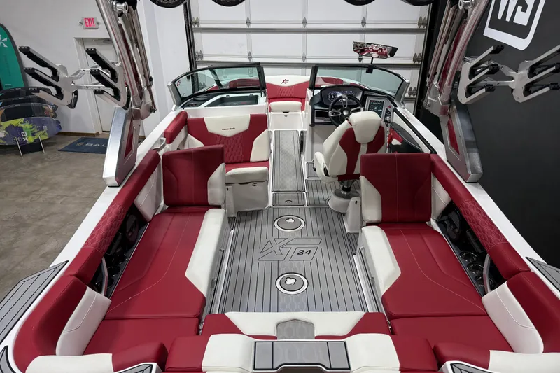 Slide: The Image of 2024 MasterCraft XT24 boat interior with red and white seating, advanced dashboard, and spacious layout. - 14