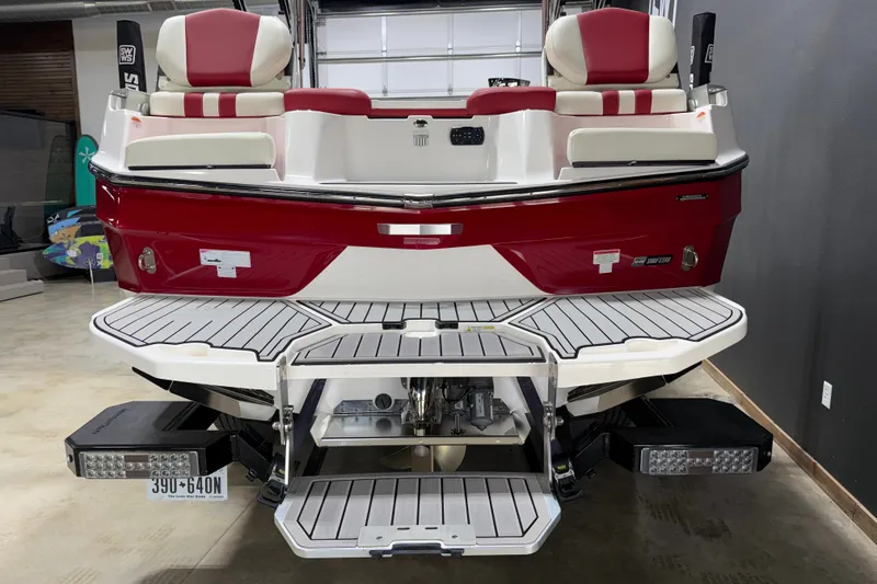 Slide: The Image of 2024 MasterCraft XT24 boat, red and white, rear view in a garage setting. - 15