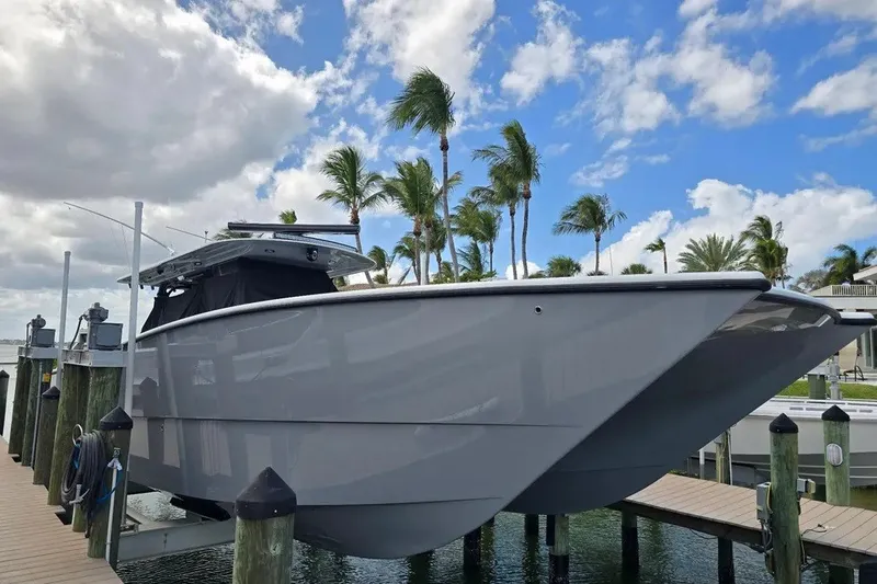 The Image of 2024 Freeman 47 boat docked, surrounded by palm trees and a partly cloudy sky. - 1