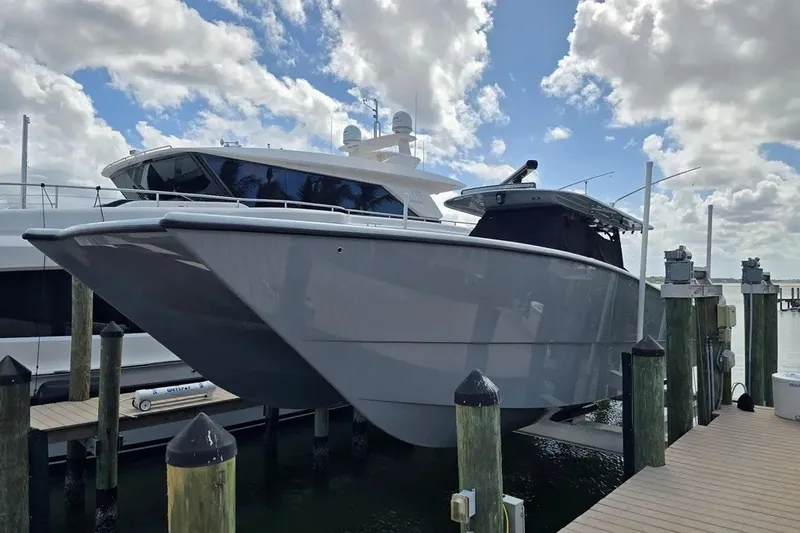 Slide: The Image of 2024 Freeman 47 boat docked under cloudy sky, showcasing sleek design. - 2