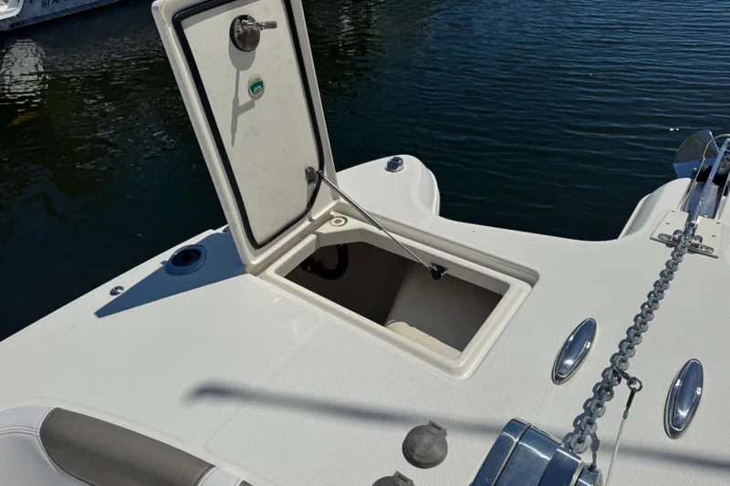 Slide: The Image of 2022 World Cat 296 DC boat with open storage compartment on deck, docked on water. - 29