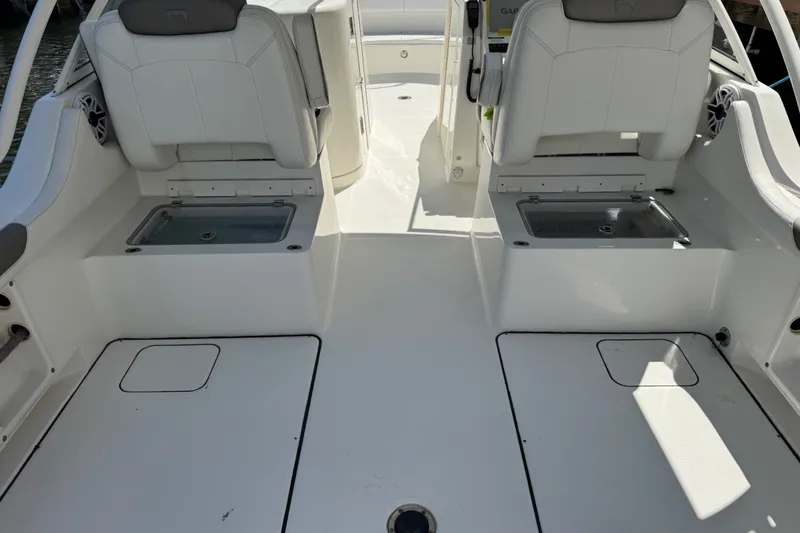 Slide: The Image of 2022 World Cat 296 DC boat interior with white seating and storage compartments. - 24