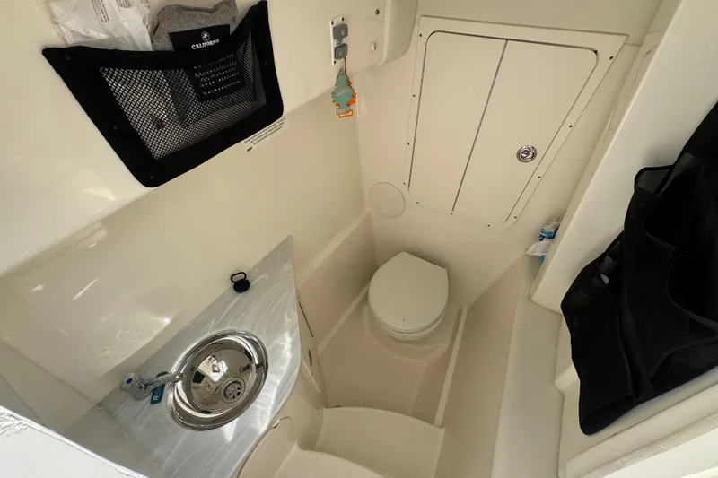 Slide: The Image of 2022 World Cat 296 DC boat interior with compact bathroom and sink. - 14
