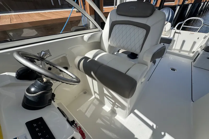 Slide: The Image of Captain's seat and steering wheel of 2022 World Cat 296 DC boat. - 16