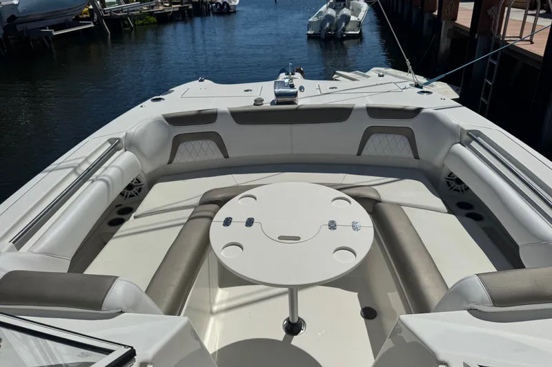 Slide: The Image of 2022 World Cat 296 DC boat interior with seating and table, docked by the water. - 18