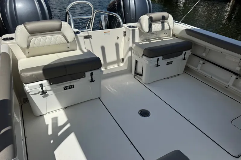 Slide: The Image of 2022 World Cat 296 DC boat interior with cushioned seating and Yeti coolers. - 9