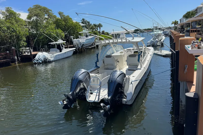 Slide: The Image of 2022 World Cat 296 DC boat docked in a scenic canal setting. - 6
