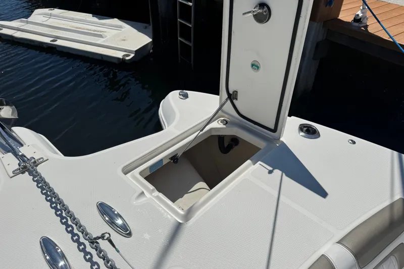 Slide: The Image of Open storage compartment on a 2022 World Cat 296 DC boat, docked by the water. - 30