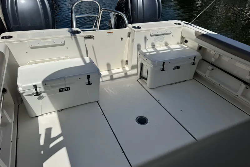 Slide: The Image of 2022 World Cat 296 DC boat deck with Yeti coolers and twin engines. - 23
