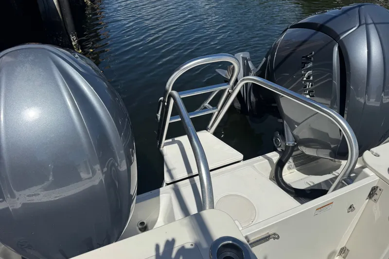 Slide: The Image of 2022 World Cat 296 DC boat with dual engines and swim ladder on calm water. - 27