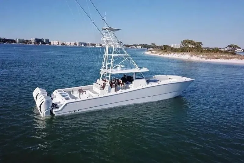 Slide: The Image of 2023 Freeman 47 boat cruising in clear blue waters near a sandy shoreline. - 5