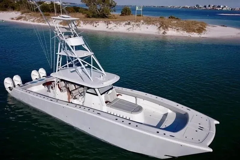 Slide: The Image of 2023 Freeman 47 boat on clear water near sandy shore. - 2