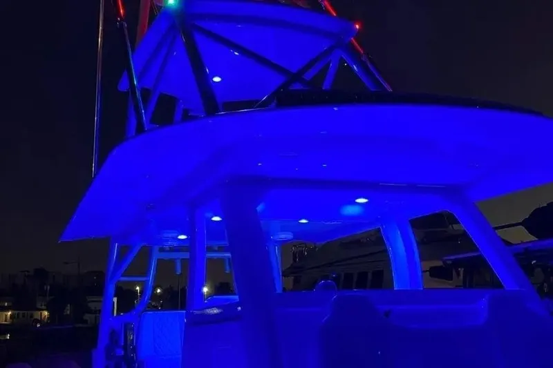 Slide: The Image of 2023 Freeman 47 boat illuminated with vibrant blue lights at night. - 11