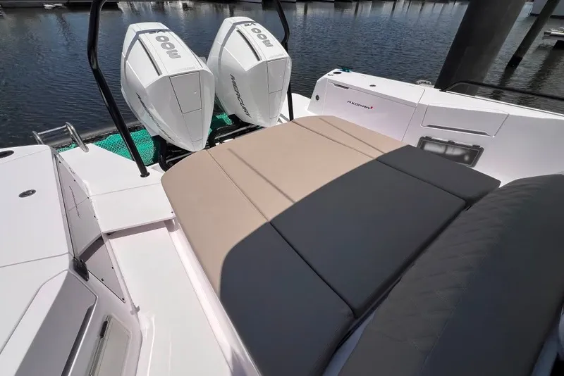 Slide: The Image of 2023 Axopar Brabus 37 Sun-Top boat with twin outboard engines, docked by the water. - 48