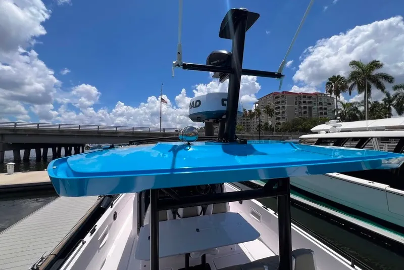 Slide: The Image of 2023 Axopar Brabus 37 Sun-Top boat with blue canopy docked under a sunny sky. - 34