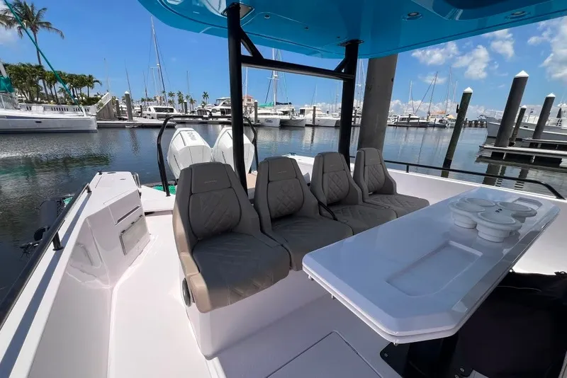 Slide: The Image of 2023 Axopar Brabus 37 Sun-Top boat interior with seating and table at marina. - 52