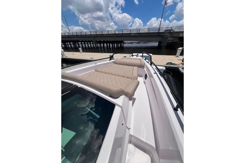 Slide: The Image of 2023 Axopar Brabus 37 Sun-Top boat with beige seating, docked under a cloudy sky. - 58