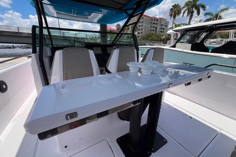 Slide: The Image of 2023 Axopar Brabus 37 Sun-Top boat interior with sleek seating and table setup. - 45
