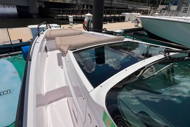 Slide: The Image of 2023 Axopar Brabus 37 Sun-Top boat with sleek design and luxurious seating at a marina. - 70