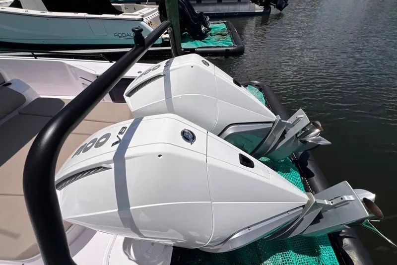 Slide: The Image of 2023 Axopar Brabus 37 Sun-Top with dual outboard engines docked on water. - 28