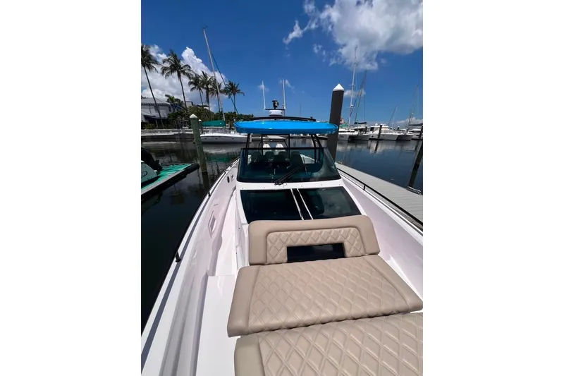 Slide: The Image of 2023 Axopar Brabus 37 Sun-Top boat docked, featuring luxurious seating and sleek design. - 61