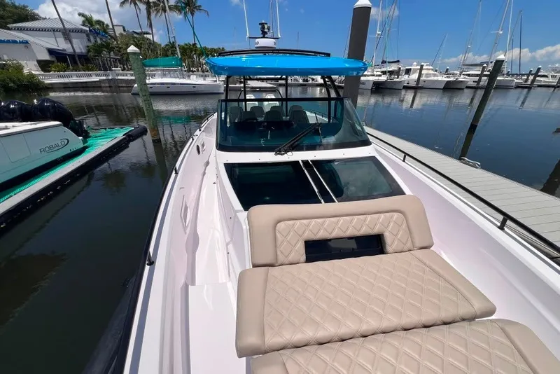 Slide: The Image of 2023 Axopar Brabus 37 Sun-Top boat docked at marina, featuring sleek design and luxurious seating. - 67