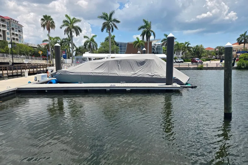 Slide: The Image of Covered 2023 Axopar Brabus 37 Sun-Top docked at a marina with palm trees. - 71
