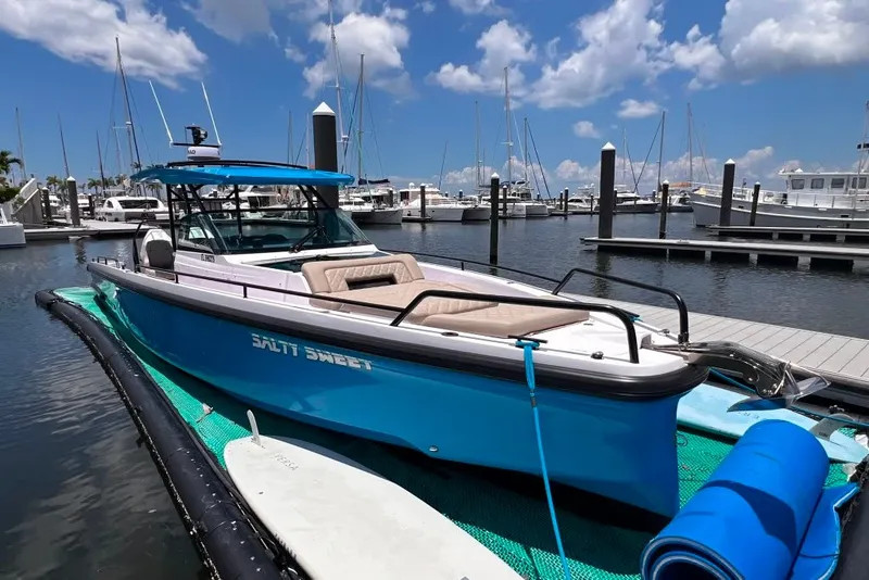 The Image of 2023 Axopar Brabus 37 Sun-Top boat docked at marina under blue sky. - 1