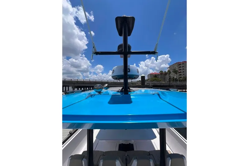 Slide: The Image of 2023 Axopar Brabus 37 Sun-Top boat with blue roof under a clear sky. - 32