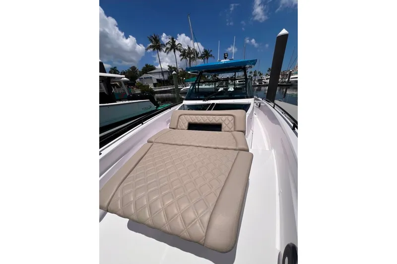Slide: The Image of 2023 Axopar Brabus 37 Sun-Top boat with luxurious seating, docked under a clear blue sky. - 62