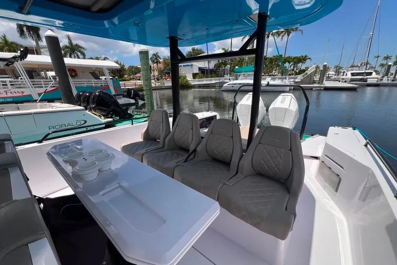 Slide: The Image of 2023 Axopar Brabus 37 Sun-Top boat interior with seating and table, docked at marina. - 55