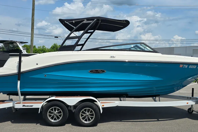 Slide: The Image of 2023 Sea Ray SPX 230 boat on trailer, vibrant blue hull, sleek design. - 4