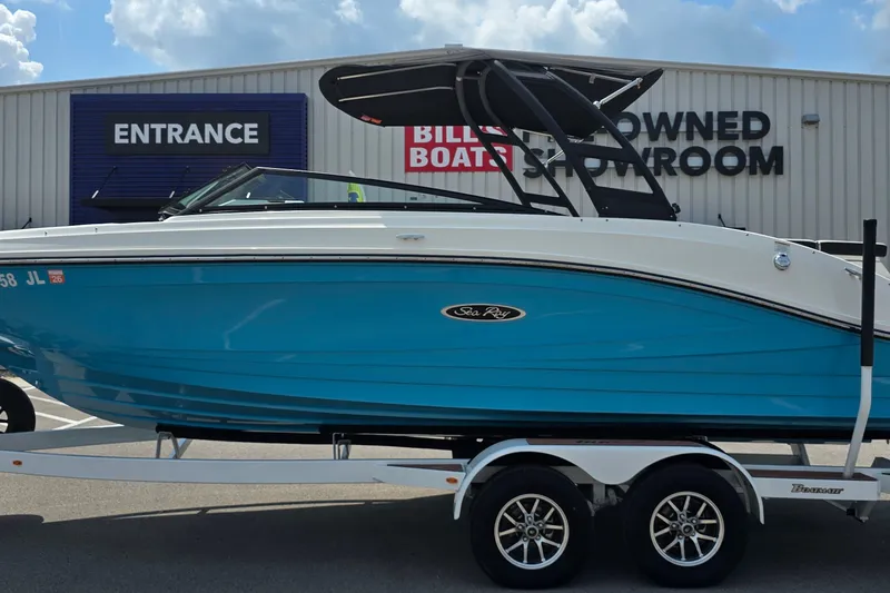 Slide: The Image of 2023 Sea Ray SPX 230 boat in blue, displayed outside a showroom on a trailer. - 1