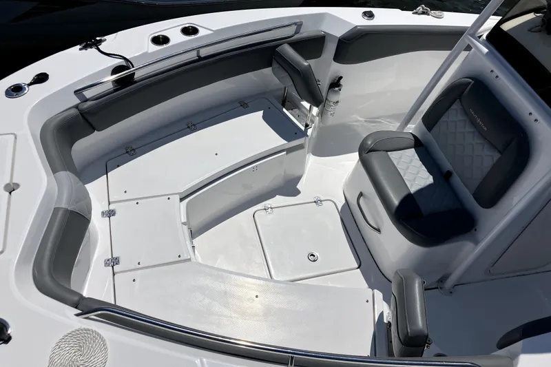 Slide: The Image of 2024 NauticStar 222L Offshore boat interior with cushioned seating and storage compartments. - 5