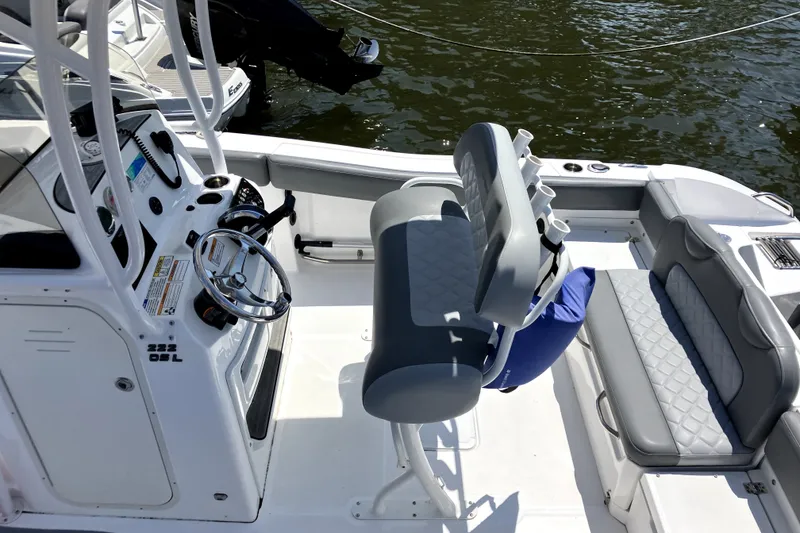 Slide: The Image of 2024 NauticStar 222L Offshore boat interior with steering console and seating. - 6