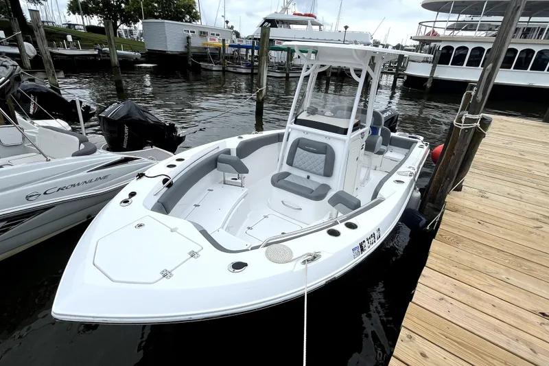 The Image of 2024 NauticStar 222L Offshore boat docked at marina, showcasing sleek design and spacious seating. - 1