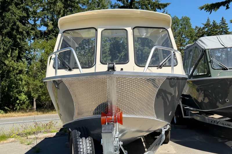 Slide: The Image of 2026 Hewescraft 200 ProV ET Hardtop boat on trailer, surrounded by trees. - 2