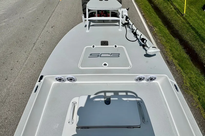 Slide: The Image of 2021 SCB R24 boat deck with speakers and trolling motor on a road. - 14