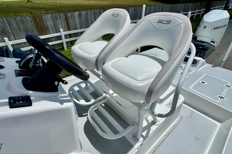 Slide: The Image of 2021 SCB R24 boat with dual white captain seats and Mercury engine. - 11