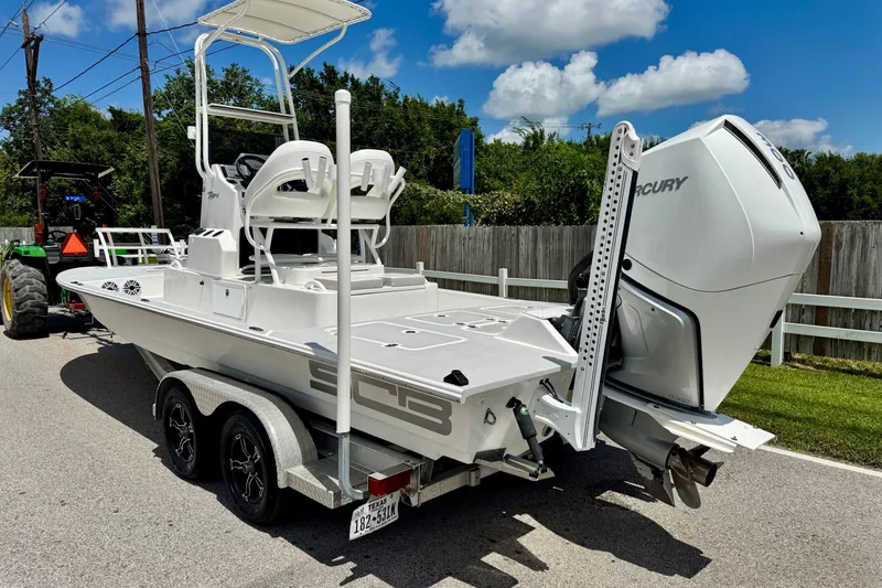 Slide: The Image of 2021 SCB R24 boat with Mercury engine on trailer, parked on a sunny day. - 2