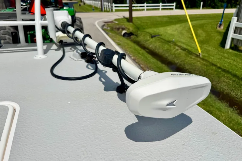 Slide: The Image of 2021 SCB R24 boat with mounted trolling motor on deck, parked near grassy roadside. - 18