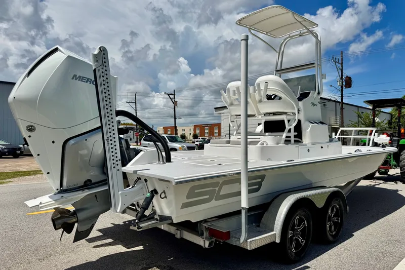 Slide: The Image of 2021 SCB R24 boat with Mercury engine on trailer, parked outdoors under cloudy sky. - 4