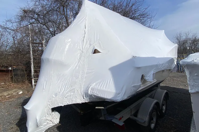 Slide: The Image of Covered 2008 Scout 222 Abaco boat on trailer, wrapped in protective white tarp. - 5
