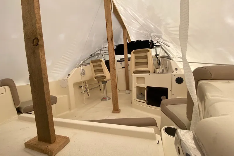 Slide: The Image of 2008 Scout 222 Abaco boat interior under protective cover, featuring seating and helm area. - 7