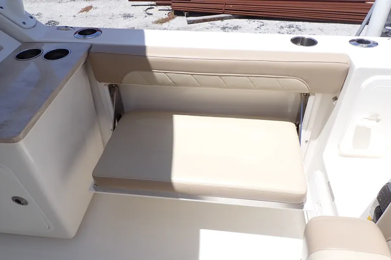 Slide: The Image of 2019 Sailfish 245 DC boat interior with beige cushioned seating and cup holders. - 19