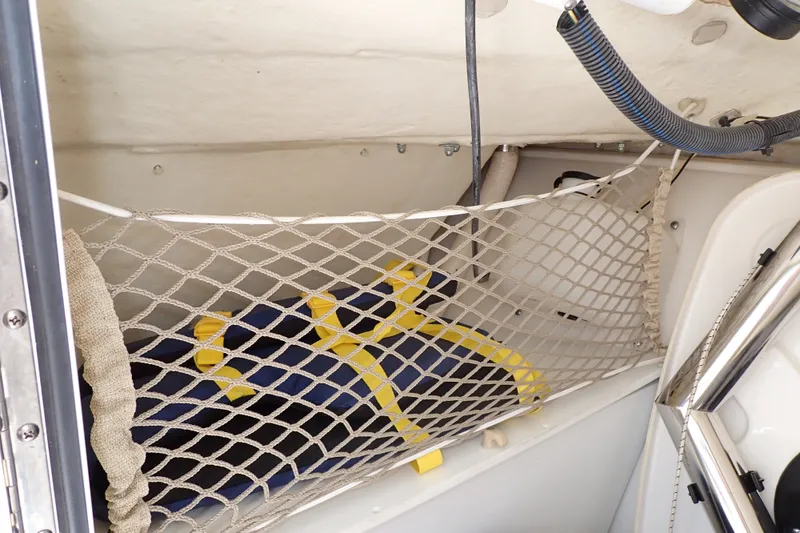 Slide: The Image of Storage compartment in a 2019 Sailfish 245 DC boat with netting and equipment. - 95