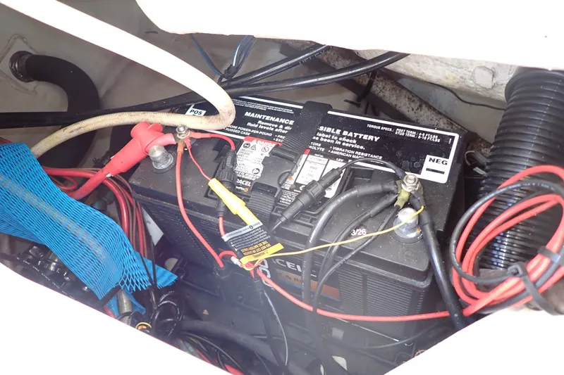 Slide: The Image of Battery compartment of a 2019 Sailfish 245 DC boat with visible wiring and connections. - 72