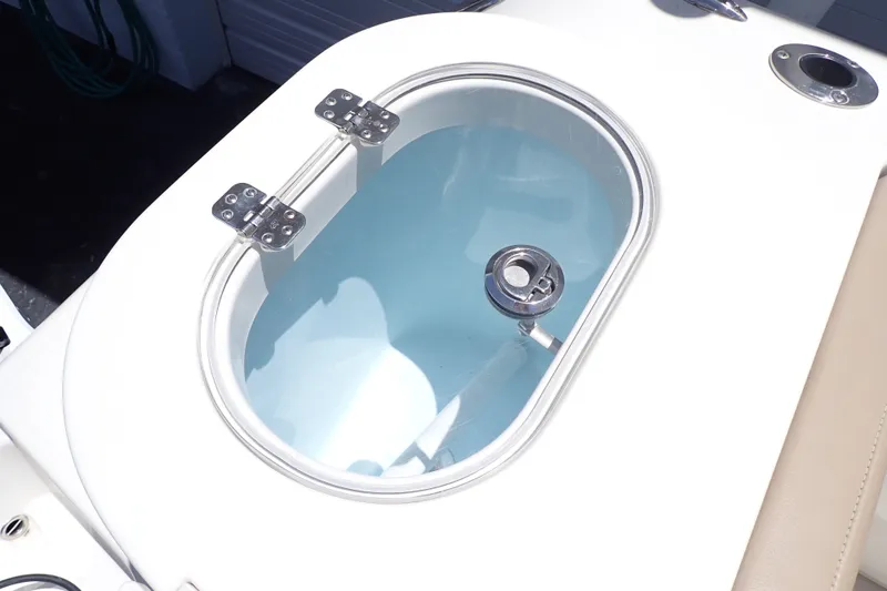 Slide: The Image of Livewell on 2019 Sailfish 245 DC boat, featuring stainless steel hinges and clear lid. - 17
